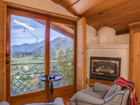 Two chairs in a suite overlooks the valley with a fireplace adjacent.