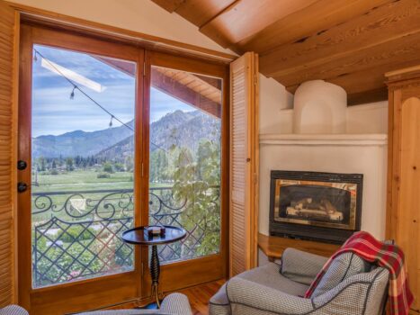 Two chairs in a suite overlooks the valley with a fireplace adjacent.
